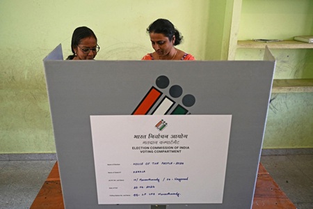 Voters standing in queue at polling booths during Kerala Assembly Election 2026 showing high voter turnout